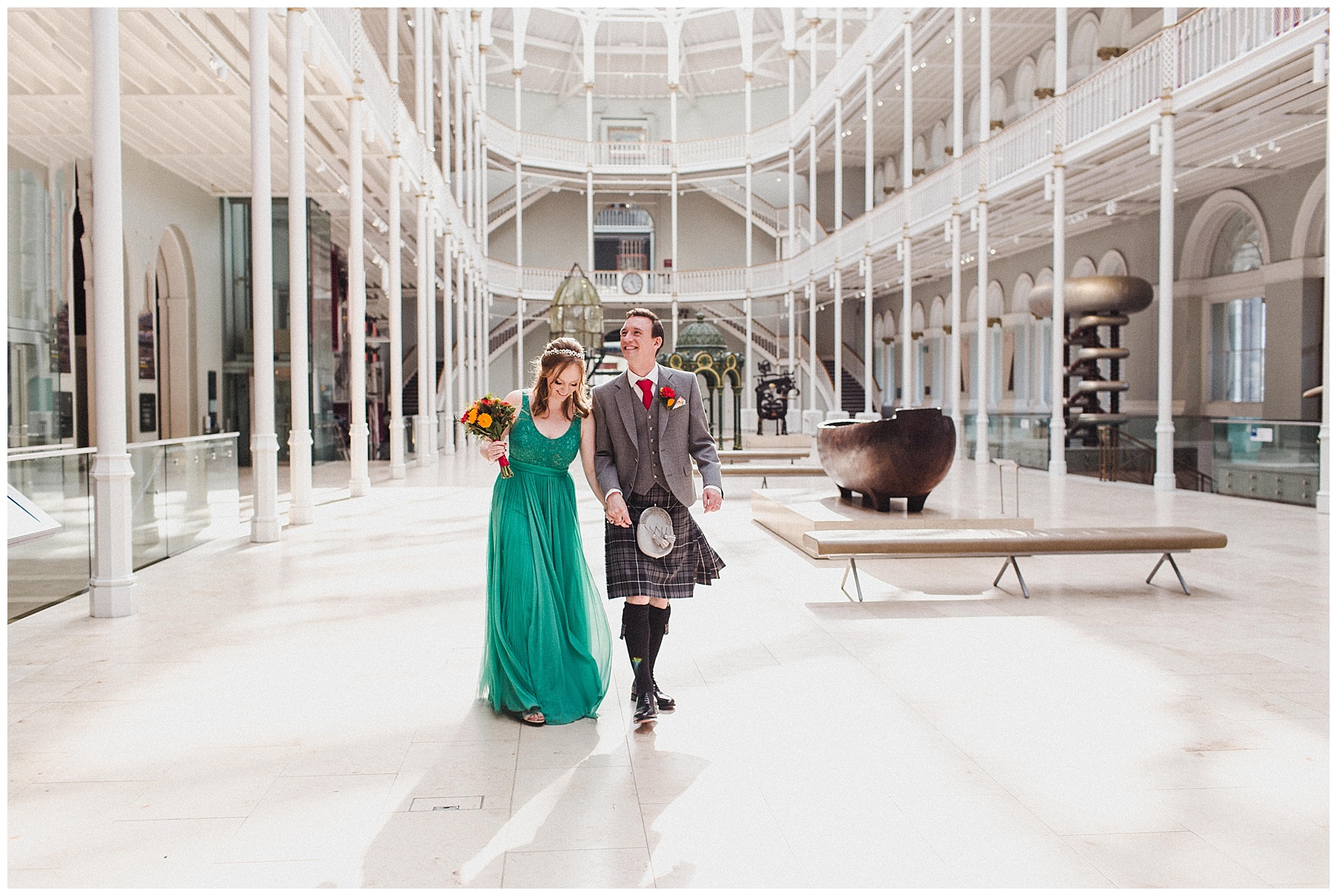 Bride and groom walking through the National Museum of Scotland
