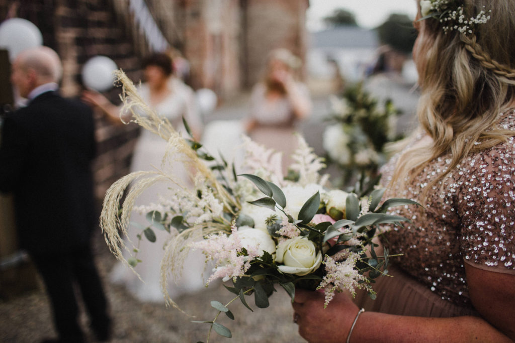 bridesmaid holding her bouquet with the bride standing in the background at Boswell's Coach House Ayrshire