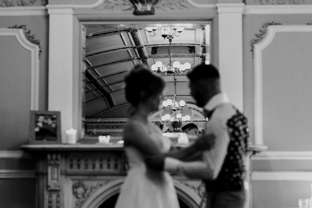 creative black and white image of a bride and groom during their wedding ceremony at Sloan's bar Glasgow