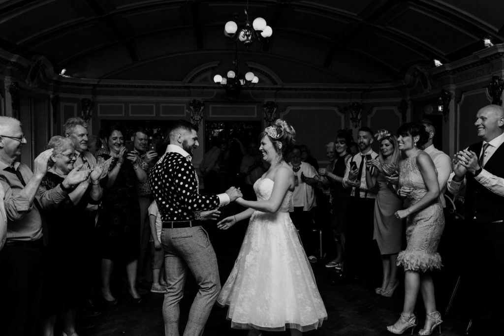 Bride and groom dancing at their wedding at Sloan's Glasgow with their guests looking on