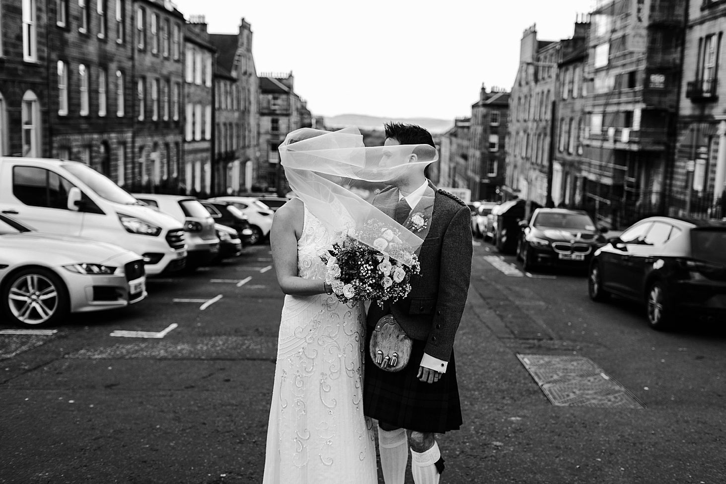 veil blows over bride's face on windy Scottish day