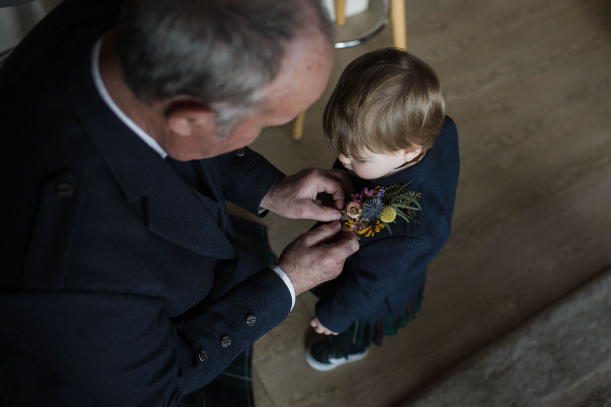 Bride's son has buttonhole pinned by grandfather