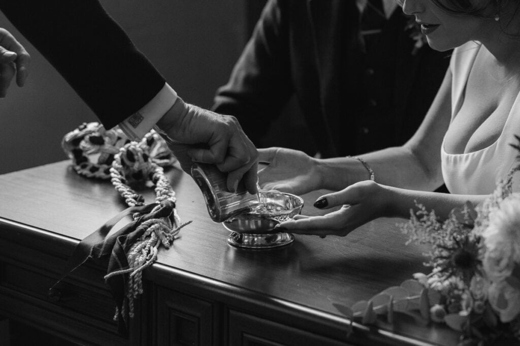 A woman receiving a traditional wedding blessing with a silver dish at a Scottish venue.