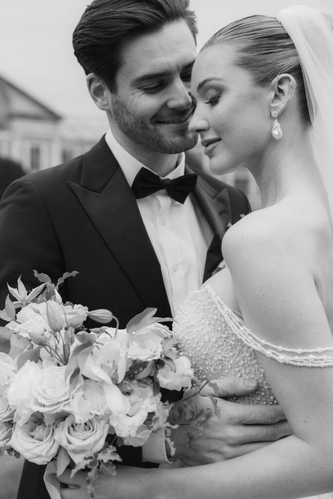 Elegant wedding couple post for a close up image of their embrace at Syon Park, London.
