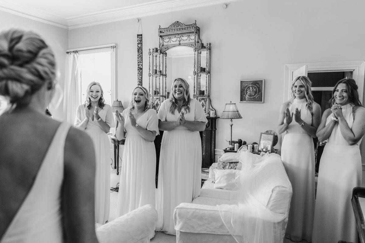 Bridesmaids in matching dresses preparing for wedding in a cozy Scottish home.