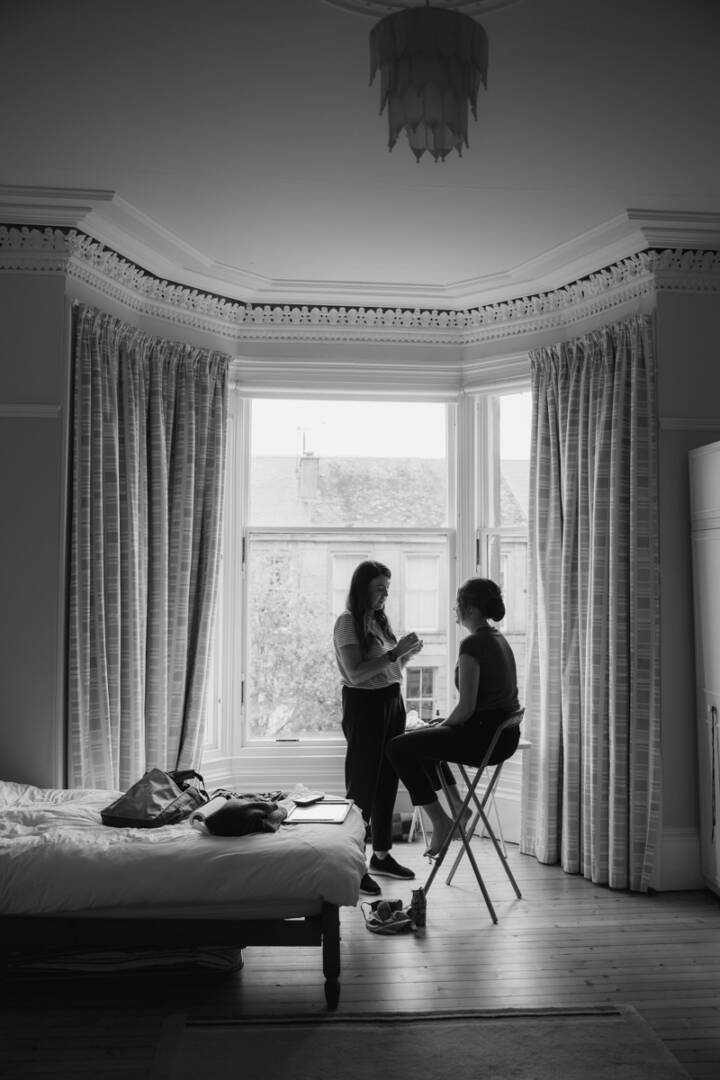 Intimate moment of bride and makeup artist in a Scottish wedding venue.