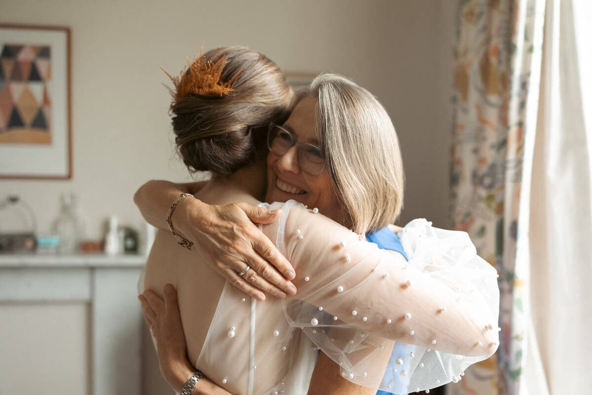 Emotional embrace between two women, celebrating a special moment at a wedding.