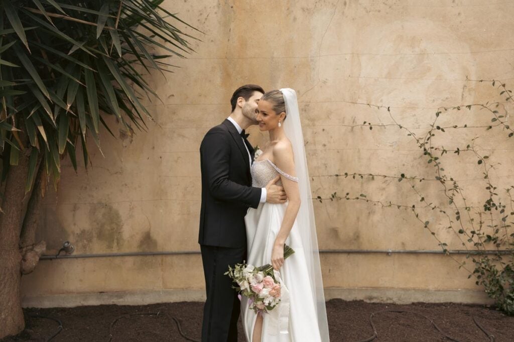 Romantic wedding couple sharing a kiss outdoors in Scotland.
